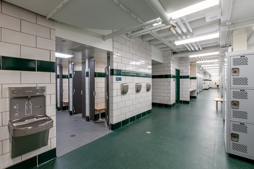 Modern locker room with benches, lockers, and showers